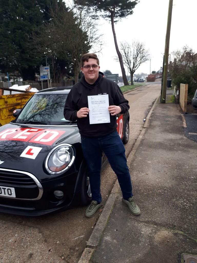 Male Person standing by mini cooper holding driving pass certificate